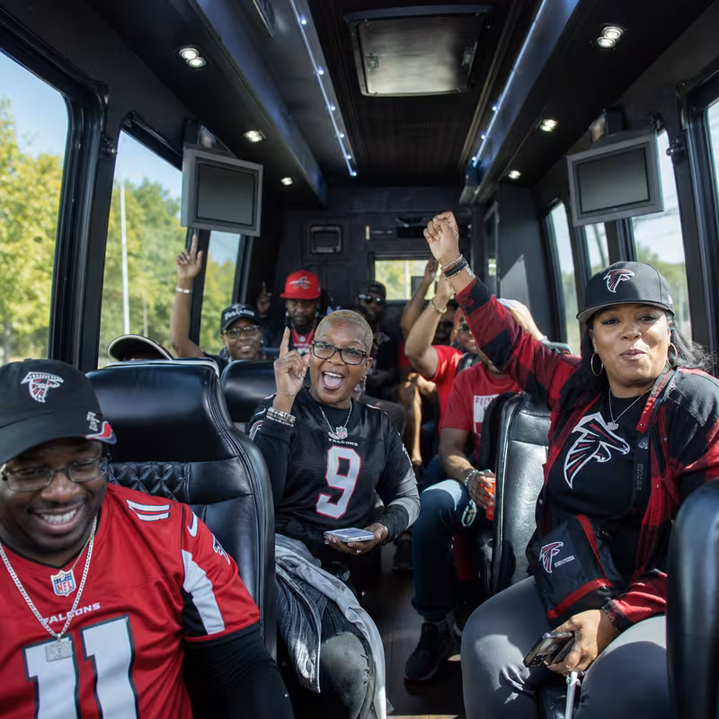 Group boarding a white charter bus for Sporting Event Transportation transportation in Atlanta